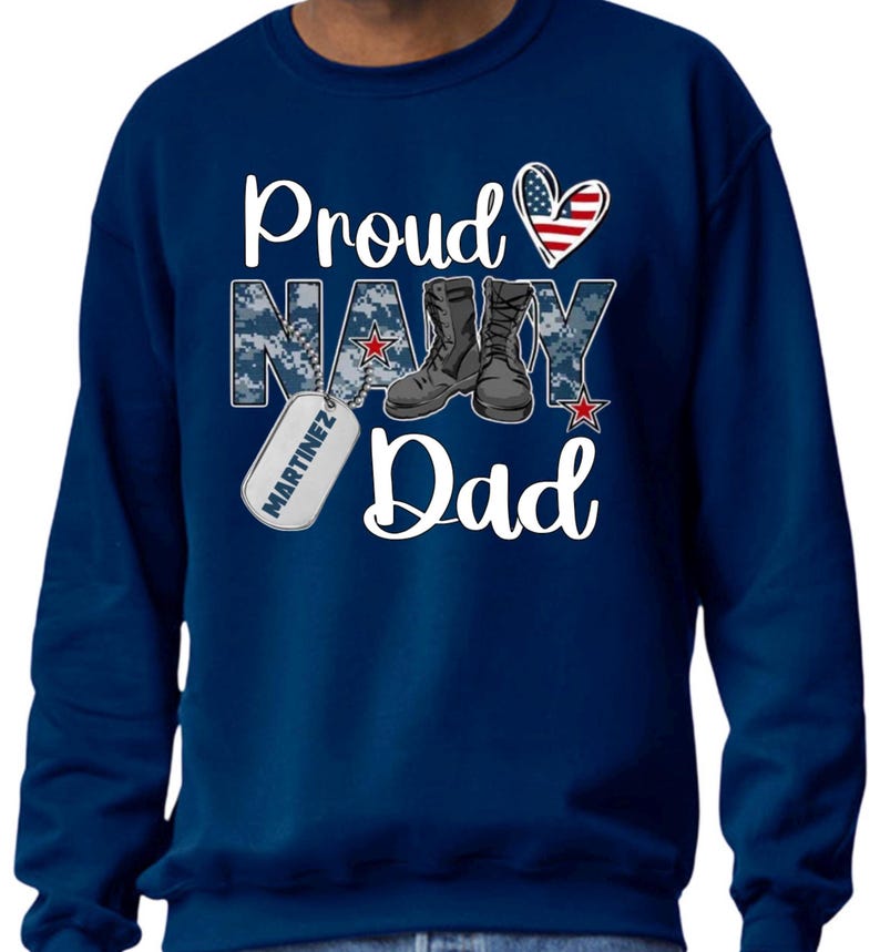 May include: Navy blue sweatshirt with a white graphic that says "Proud Navy Dad" with a red, white, and blue heart, a pair of boots, and a dog tag that says "Martinez".