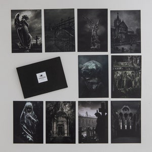 May include: A set of ten black and white photographs featuring various gothic and cemetery imagery. The images include a gate, a skull, a church, and angels.