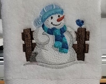 Embroidered Bathroom Hand Towel Featuring Snowman Against A Fence