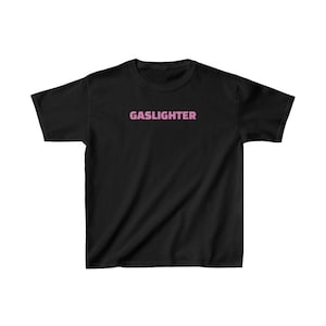 May include: Black t-shirt with the word "GASLIGHTER" printed in pink on the front.