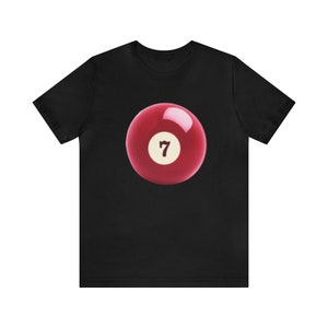 Może przedstawiać: Czarny T-shirt z czerwoną bilą z numerem 7.