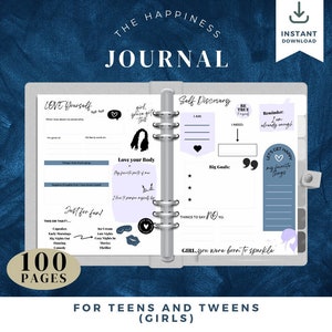 May include: A gray and white journal cover with the text "The Happiness Journal" in black. The cover also features a pink heart, a black and white illustration of a girl with curly hair, and the text "Girl, you were born to sparkle". The journal is designed for teens and tweens.