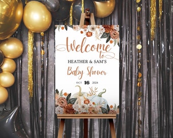 Könnte beinhalten: Willkommen zur Babyparty von Heather & Sam Schild mit weißem Hintergrund, orangefarbenen und weißen Kürbissen und floralen Akzenten. Das Datum ist der 16. Oktober 2024.