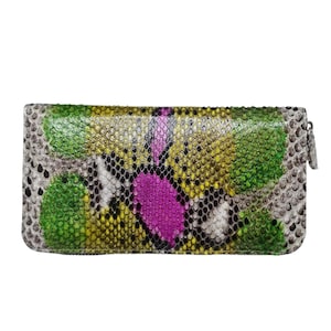 May include: A rectangular zip-around wallet featuring a textured snakeskin pattern in vibrant shades of green, yellow, and bright magenta, with neutral gray and black scales bordering the edges and a silver-toned metal zipper pull on the side.