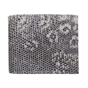 May include: A bi-fold wallet with a snakeskin pattern. The wallet is primarily white and gray, with black accents. The texture of the wallet is visible, and the design is symmetrical. The wallet is rectangular and appears to be made of leather.
