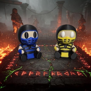 Könnte beinhalten: Zwei kleine Plüschfiguren, eine in einem blauen und eine in einem gelben Ninja-Outfit, beide mit schwarzen Masken, großen weißen ovalen Augen und schwarzen Stiefeln, sitzen auf einer dunklen Steinplattform mit leuchtend roten Runen.