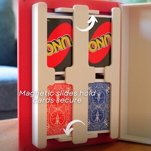 May include: A red and white card holder with two decks of cards. One deck is an UNO card, and the other is a blue and red deck of cards. The text "Magnetic slides hold cards secure" is visible.