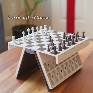 May include: A portable chess set with a brown and white checkered board and black and white chess pieces. The set is open and ready to play, with the text "Turns into Chess" in the upper left corner.