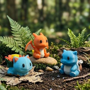 May include: Three colorful figurines of popular characters from a video game franchise. The figurines are orange, blue, and light blue, and are set in a natural outdoor environment with greenery and rocks.