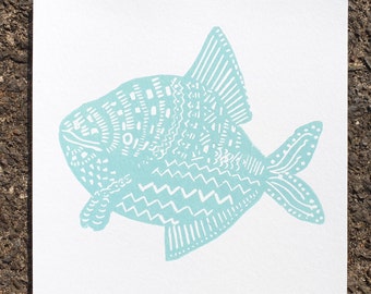 May include: A light blue fish with a white patterned design. The fish is stylised and has a large, round body and a small tail.