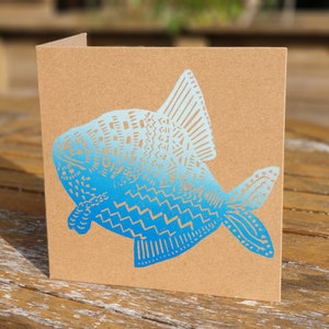 Carte bleue de poisson de mélange sur le papier brun d'artisanat
