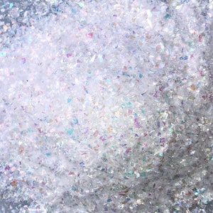 Pode incluir: Close-up de glitter branco iridescente, perfeito para artesanato e adicionar brilho aos projetos.
