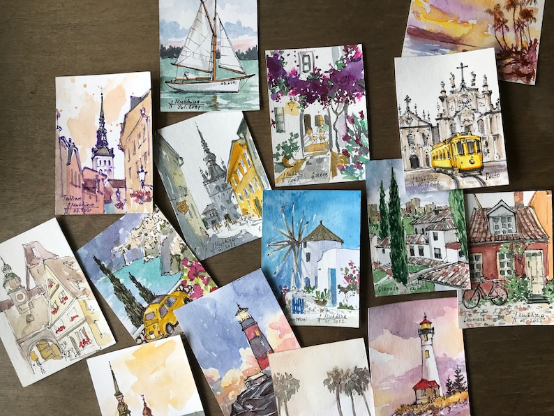 May include: A collection of 14 watercolor paintings on paper, each depicting a different city or town. The paintings are all in a similar style, with a focus on architecture and urban landscapes. Some of the paintings include text, such as "Tallinn,  Estonia" and "Porto".