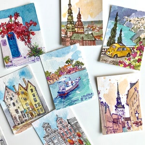 May include: A collection of watercolor paintings depicting various cityscapes. The paintings feature buildings, churches, and boats in a variety of colors, including blue, red, green, and yellow. Each painting is signed with the city name and date.