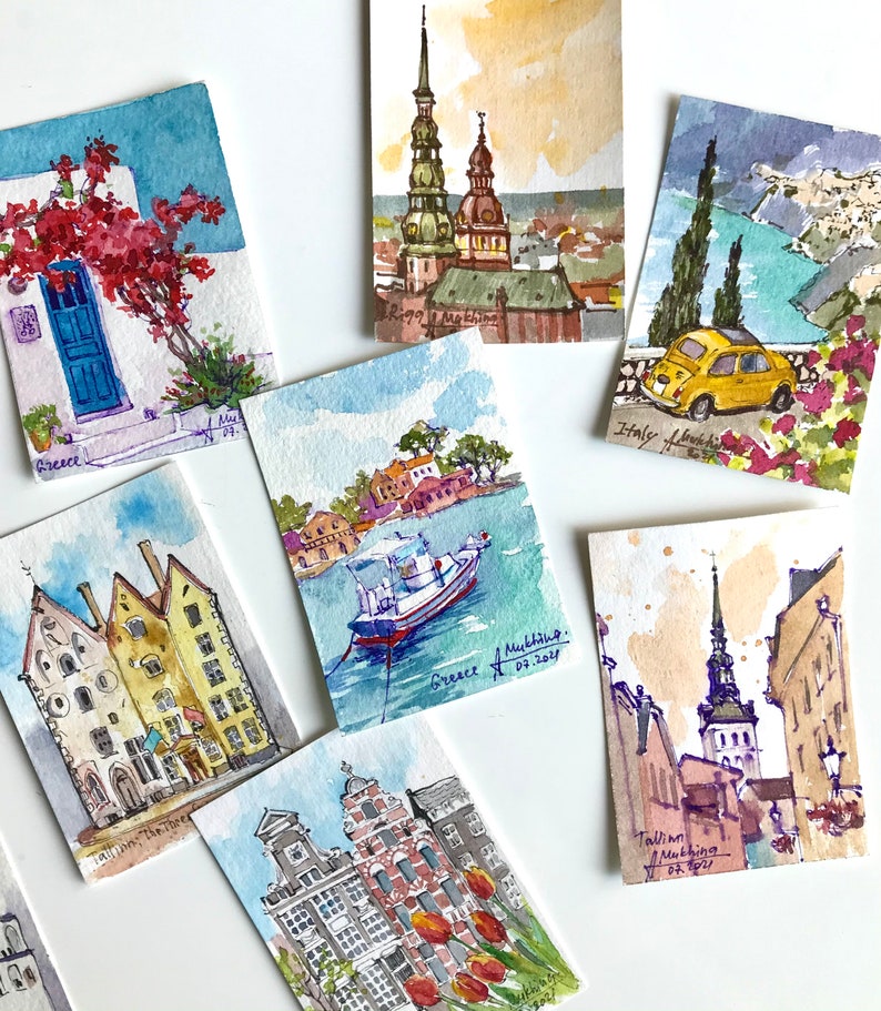 May include: A collection of watercolor paintings depicting various cityscapes. The paintings feature buildings, churches, and boats in a variety of colors, including blue, red, green, and yellow. Each painting is signed with the city name and date.