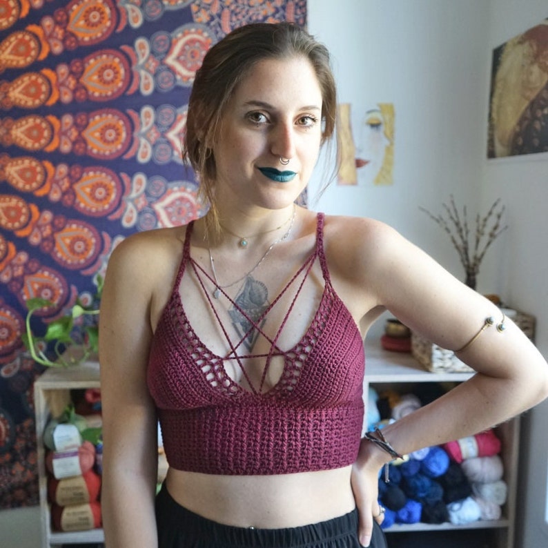 Peut inclure: Gros plan d'une femme portant un haut court en crochet marron avec un motif en croisillon. Le haut a un d&eacute;collet&eacute; en V profond et est r&eacute;alis&eacute; avec un fil fin.