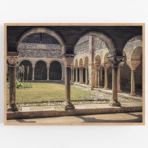 Könnte beinhalten: Blick auf einen Innenhof mit Steinbögen und Säulen. Der Innenhof ist von einer Steinmauer umgeben und hat eine grasbewachsene Fläche in der Mitte.