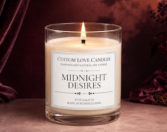 May include: A lit soy candle in a clear glass jar with a white label reading Custom Love Candles, Hand-Poured Natural Soy Candle, Midnight Desires, 8 oz, Made in Pennsylvania. The candle features a single burning wick and off-white wax.