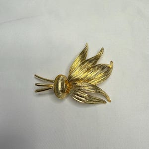 Vintage large floral gold tone brooch in near mint vintage condition; signed M. Vintage leaves brooch in gold tone.