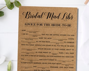 Op de afbeelding: Een bruine kaart met de tekst "Bridal Mad Libs" en "Advice for the Bride-to-Be" in elegant schrift. De kaart heeft invulvakken voor een leuke huwelijksactiviteit. Groen en wit lint voegen een decoratief tintje toe.