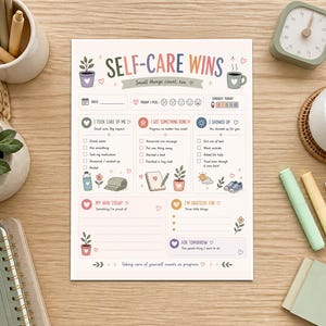 May include: A white paper self-care planner sheet titled SELF-CARE WINS with sections for daily tracking, mood, energy, gratitude, and goals. The layout features colorful pastel illustrations of plants, a coffee mug, and icons for daily tasks.