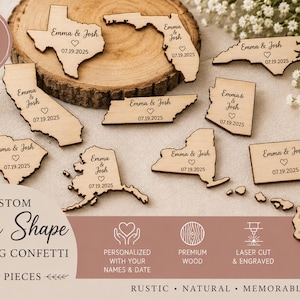 Può includere: Una collezione di ritagli in legno chiaro a forma di vari stati americani, ognuno inciso con i nomi Emma & Josh, un simbolo a forma di cuore e la data 07.19.2025. I pezzi sono disposti su una superficie piana accanto a una fetta di legno.