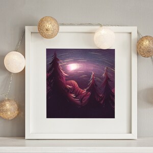 Puede incluir: Una impresión artística enmarcada que presenta una escena nocturna de bosque con árboles altos y oscuros y una luna brillante. La obra de arte está en un marco blanco y está decorada con luces de cadena con esferas blancas y doradas.