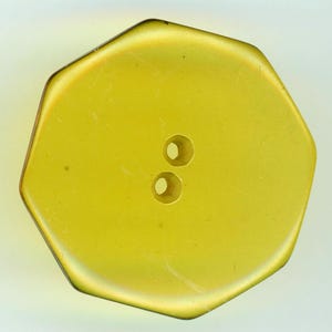 May include: A yellow, hexagonal button with two holes. The button has a slightly iridescent finish and a subtle, darker edge. This sewing notion is suitable for various craft projects.