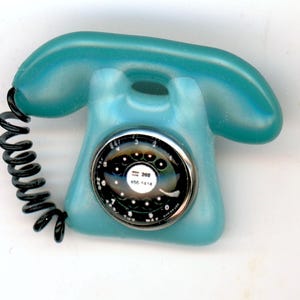 May include: A set of three ceramic mugs with a speckled, cream-colored glaze. Each mug features a different hand-painted floral design in shades of blue, green, and yellow. The mugs have a simple, rounded shape and a comfortable handle.