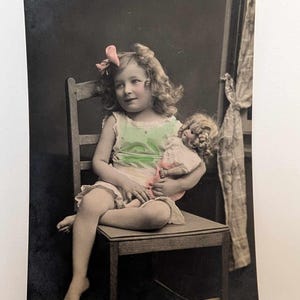 Cartão postal antigo com foto real de menina com boneca na cadeira, pintado à mão, RPPC, saudações de aniversário da década de 1910, Noruega, retrato infantil vintage