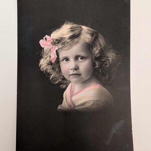 Postal antigua de niña noruega con lazo rosa de la RPPC. Foto real enviada a Londres, Inglaterra. Retrato coloreado a mano, principios del siglo XX.