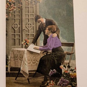 Carte postale romantique vintage des années 1920, scène de couple avec des fleurs et un livre | imprimée colorée à la main en allemand | Éphémères européens anciens