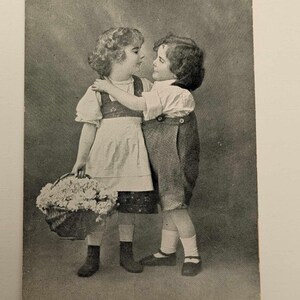 Vintage Postkarte mit umarmenden Kindern - Foto von Jungen und Mädchen mit Blumenkorb - Süßer Anhänger aus der Edwardian Ära