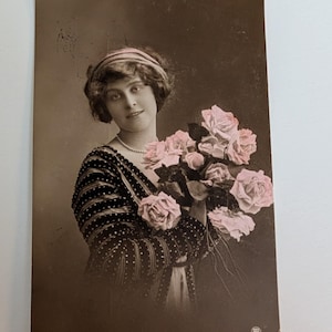 Postal antigua RPPC de 1912 con foto real de una mujer con rosas rosadas. Foto coloreada a mano. Sello de Noruega. Romance eduardiano.