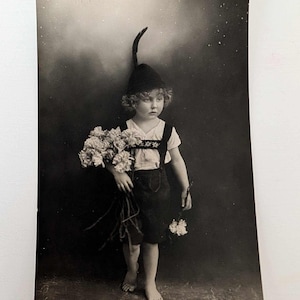 Ancienne vraie carte postale photo enfant avec fleurs, garçon aux pieds nus, chapeau et plumes RPPC Allemagne 34843/5 vintage