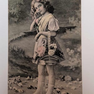 Postal antigua de 1911 de "Niña con cesta de flores" (enviada desde Noruega), coloreada a mano. Una encantadora niña eduardiana.