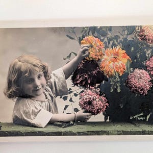 Cartolina fotografica francese d'epoca con foto reali Ragazza con fiori colorati di Stebbing Paris, ritratto di bambino colorato a mano