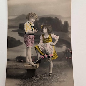 Cartolina fotografica d'epoca del 1923 – Ragazzo e ragazza dipinti a mano sul fiume, cesto di fiori, Norvegia RPPC