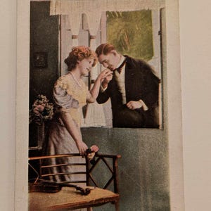 Cartolina edoardiana Coppia alla finestra con violino, scena di bacio della mano, cartolina romantica d'epoca n. 47, cartolina d'amore dei primi anni del 1900
