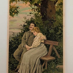 Pareja eduardiana en un banco de parque – Postal antigua de 1909-1910 – Litografía romántica, postal vintage en relieve con saludo manuscrito