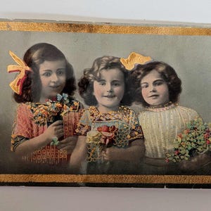 Postal antigua en relieve de tres niñas con detalles dorados – Principios del siglo XX – Acentos brillantes – Tarjeta de felicitación noruega – Década de 1910