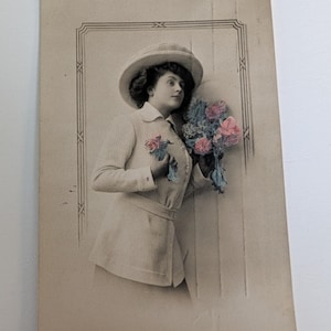 Cartão postal vintage da década de 1910 com foto real de mulher com chapéu e flores, colorido à mão, RPPC Noruega, enviado em 1906