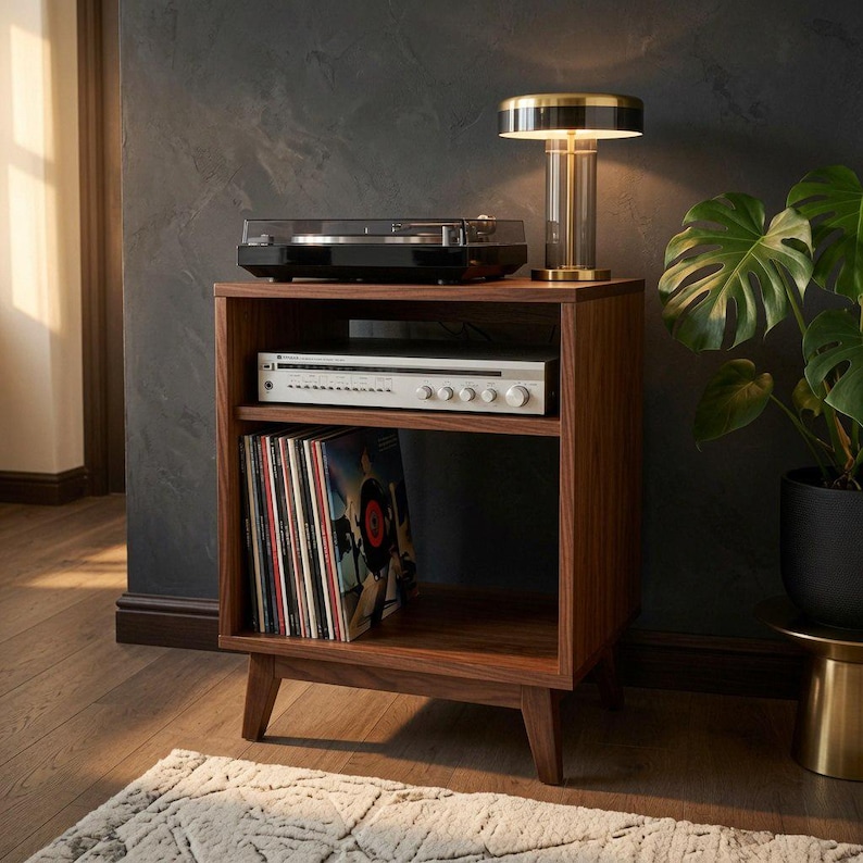 Puede incluir: Un soporte de madera para tocadiscos con cuatro patas c&oacute;nicas, que cuenta con un estante superior abierto con un tocadiscos negro, un estante central con un receptor de audio plateado y un estante inferior con una colecci&oacute;n de discos de vinilo.