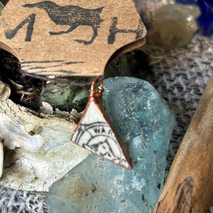 Tiny Sea Pottery pendant with markings.