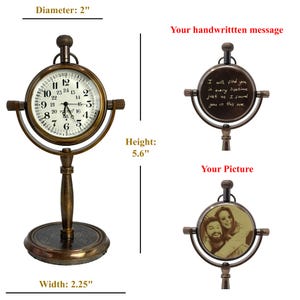 K&ouml;nnte beinhalten: Eine antike Tischuhr aus Messing mit rundem Zifferblatt, 5 cm Durchmesser, mit r&ouml;mischen Ziffern und Zeigern. Die Uhr ist 14,2 cm hoch und 5,7 cm breit. Das Bild zeigt auch Platz f&uuml;r eine handschriftliche Nachricht und ein Bild.