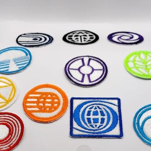 May include: A collection of embroidered patches in various shapes and colors. Designs include geometric patterns, a globe, and stylized waves. The patches feature white stitching on colored backgrounds, with orange, blue, green, and purple accents.