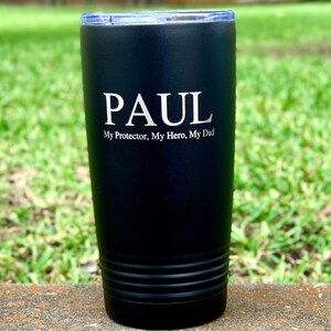 May include: Black stainless steel tumbler with a personalized inscription that reads "PAUL My Protector, My Hero, My Dad".