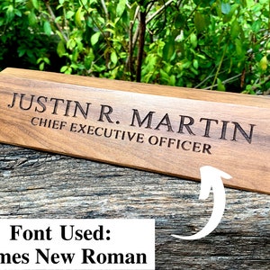 May include: A wooden desk nameplate with the text "JUSTIN R. MARTIN CHIEF EXECUTIVE OFFICER" engraved in a Times New Roman font.