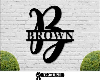 May include: Black metal personalised monogram sign with the letter "B" and the last name "BROWN" displayed against a white brick wall background.