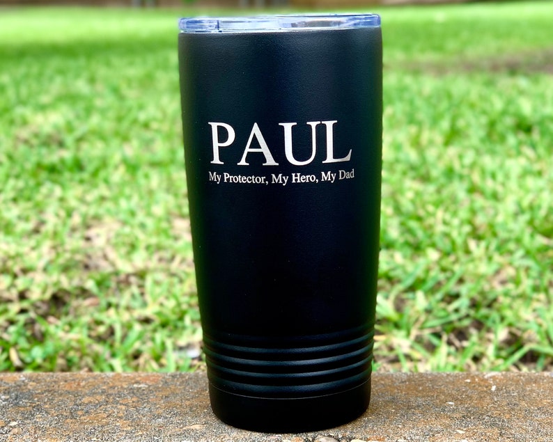 May include: Black stainless steel tumbler with a personalized inscription that reads "PAUL My Protector, My Hero, My Dad".